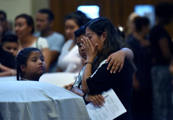 Lawrenceville - Family members mourn in front of the caskets of the victims â€” Martin Romero, 33, and four of his children â€” before the funeral mass for at St. Lawrence Catholic Church in Lawrenceville on July 13, 2017. Thirty-three-year-old Martin Romero and children Axel, 1, Dillan, 4, Dacota, 6 and Isabela Martinez, 10, were stabbed to death last week in their Loganville home. Nine-year-old daughter Diana Romero survived the attack. HYOSUB SHIN / HSHIN@AJC.COM