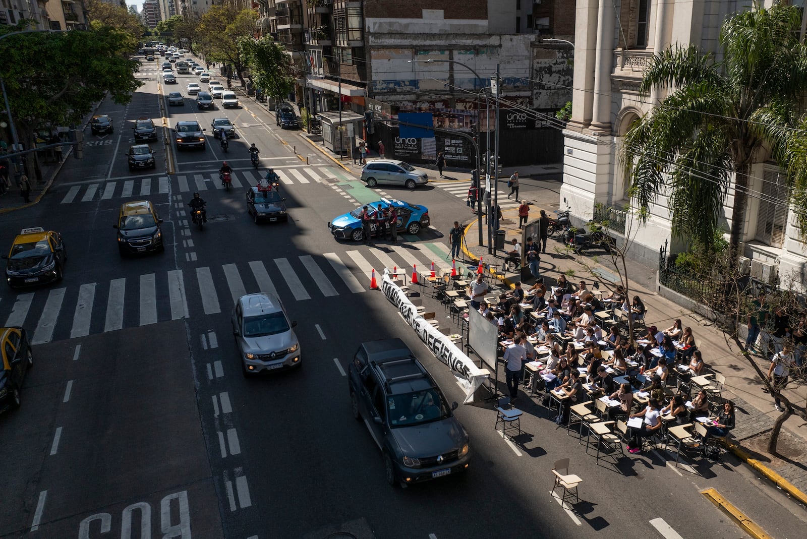 Economics students hold class outside in front of the University of Buenos Aires to protest President Javier Milei's veto of higher funding for public universities in Buenos Aires, Argentina, Wednesday, Oct. 16, 2024. (AP Photo/Victor R. Caivano)