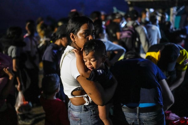 Venezuelan migrant Luisleibis Navarro carries her son, as he waits to board a boat departing from Panama's Caribbean coastal village of Miramar to the border with Colombia, Thursday, Feb. 27, 2025. Migrants are returning from southern Mexico after giving up on reaching the U.S., a reverse flow triggered by President Trump administration's immigration crackdown. (AP Photo/Matias Delacroix)