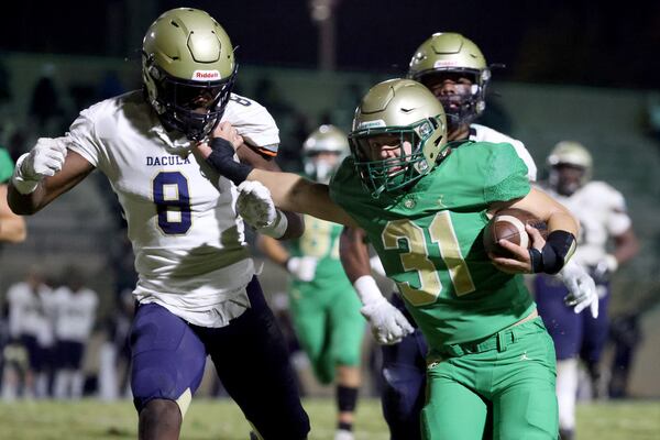 Buford running back Eli Parks (31) runs a fake punt for a first down against Dacula defensive lineman Festus Davies (8) in the first half at Buford Friday.