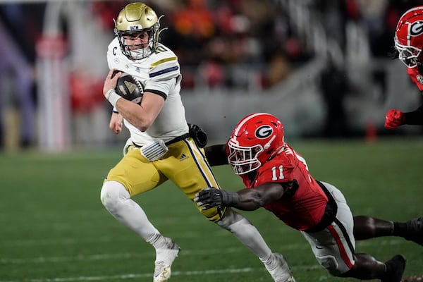 Georgia Tech quarterback Haynes King (10) runs against Georgia linebacker Jalon Walker (11) during the first half of an NCAA college football game, Friday, Nov. 29, 2024, in Athens, Ga. (AP Photo/Mike Stewart)