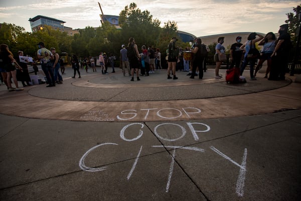 Protestors march to the World of Coca-Cola to demonstrate against the proposed police training facility during a rally on Friday, Sept 3, 2021. (Jenni Girtman for The Atlanta Journal-Constitution)