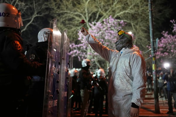 A protester holds up a flower in front of riot policemen during a protest against the arrest of Istanbul's Mayor Ekrem Imamoglu, in Istanbul, Turkey, Saturday, March 22, 2025. (AP Photo/Francisco Seco)