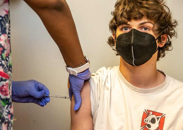 DeKalb Pediatric Center administers Jude Hiley, 16, his first dose of the Pfizer vaccination Thursday.  The office expects long lines for the first week when 15-year-olds and younger become are eligible for covid vaccines.  (Jenni Girtman for The Atlanta Journal-Constitution)