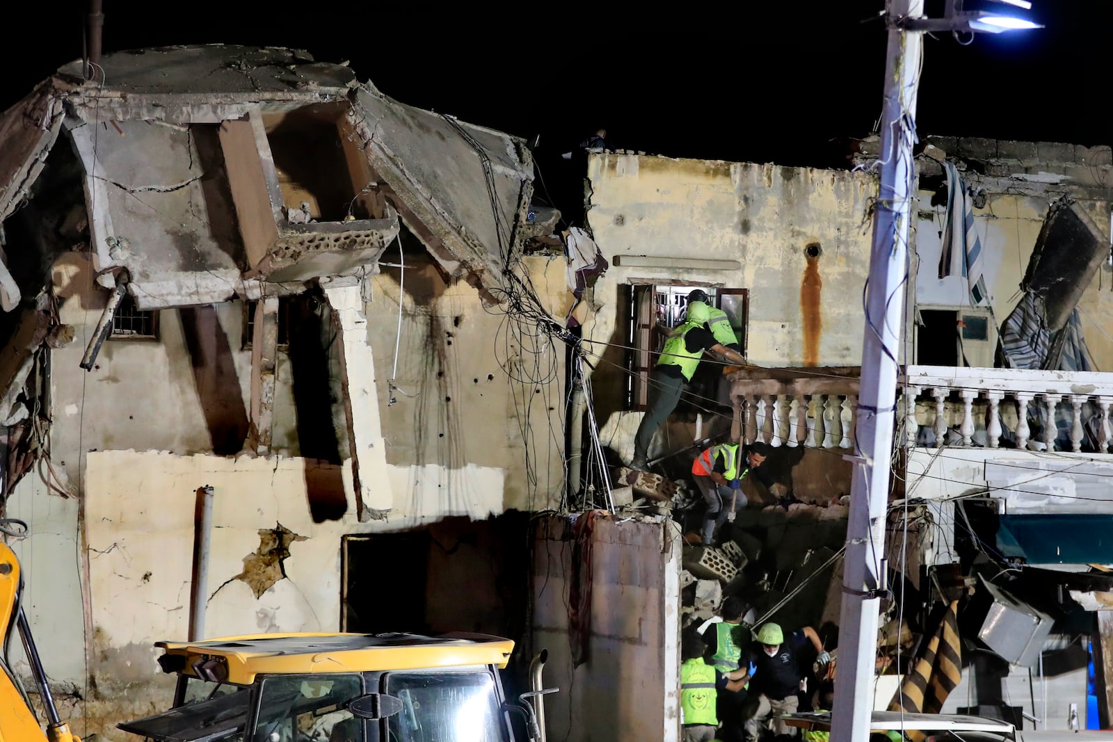 Rescue workers search for victims at a destroyed building hit in an Israeli airstrike, in the southern port city of Sidon, Lebanon, Tuesday, Oct. 29, 2024. (AP Photo/Mohammed Zaatari)