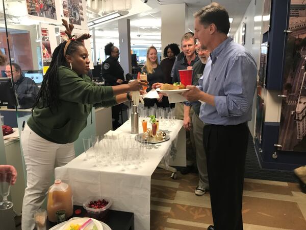 Reporter Rosalind Bentley stands behind a makeshift bar serving mocktails to a thirsty newsroom. LIGAYA FIGUERAS/LFIGUERAS@AJC.COM