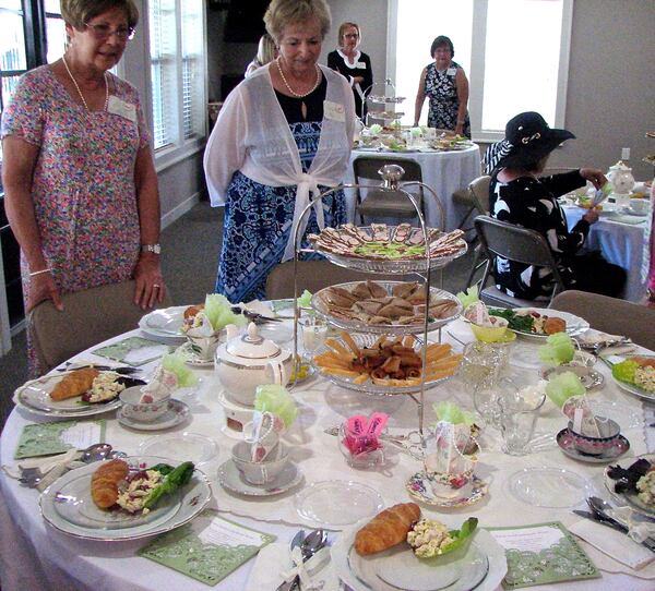 Eyeing the set-up for ladies tea, a few Heron Pond residents take in the tablescape before picking their seat.