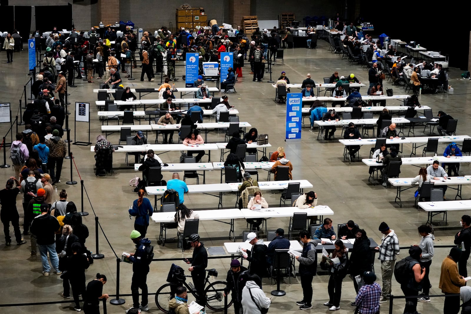 Voters wait in line and fill out their ballots at a voting center at Lumen Field Event Center on Election Day, Tuesday, Nov. 5, 2024, in Seattle. (AP Photo/Lindsey Wasson)