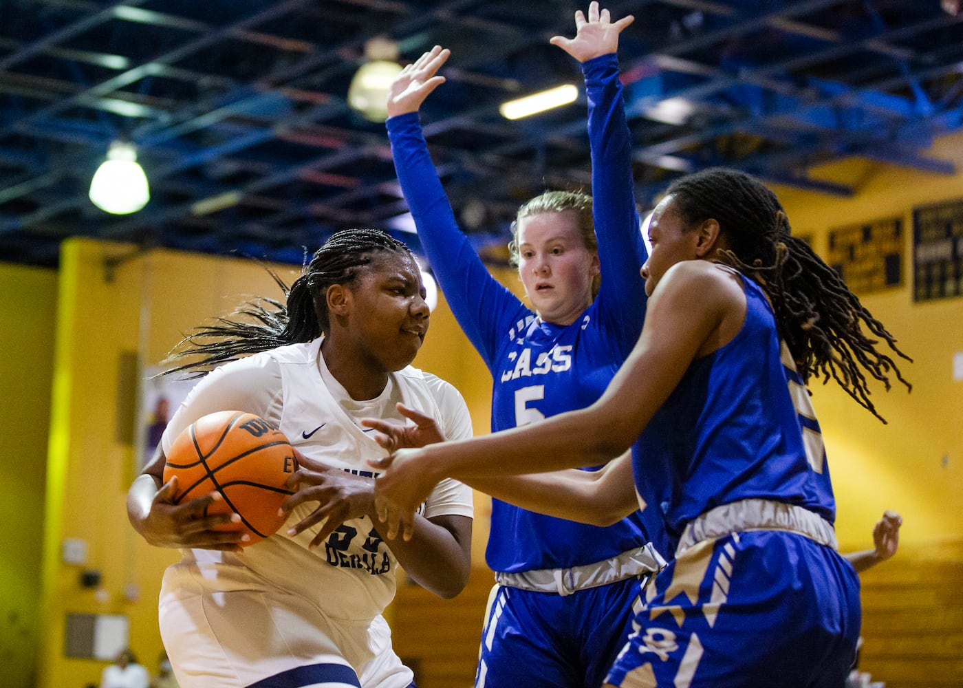 Adrieanna Browniee (left), center for South Dekalb High School, drives past Haley Johnson (middle), guard for Cass High School, and Londaisha Smith (right), wing for Cass High School during the South Dekalb vs. Cass girls basketball playoff game on Friday, February 26, 2021, at South Dekalb High School in Decatur, Georgia. South Dekalb defeated Cass 72-46. CHRISTINA MATACOTTA FOR THE ATLANTA JOURNAL-CONSTITUTION