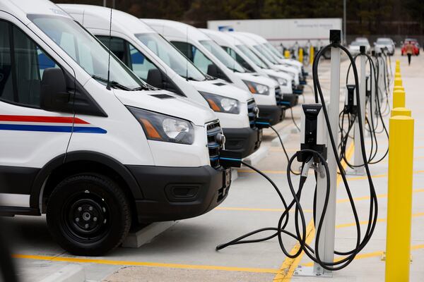 Several United States Postal Service vans are seen charging during the unveiling of the first of tens of thousands of electric vehicles and charging stations deployed nationally to power the country's largest electric delivery fleet on Monday, Jan. 22, 2024. (Miguel Martinez/The Atlanta Journal-Constitution/TNS)