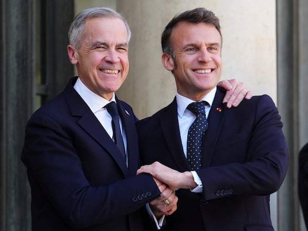 Canada Prime Minister Mark Carney, left, is greeted by President of France Emmanuel Macron as he arrives at the Palais de l'Elysee in Paris, on Monday, March 17, 2025. (Sean Kilpatrick/The Canadian Press via AP)