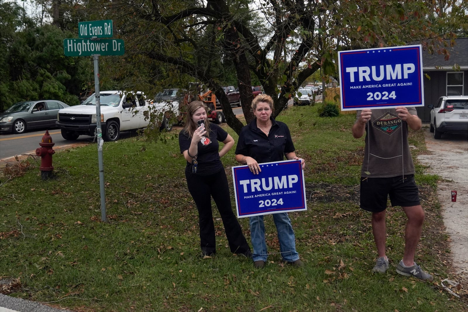 People watch as the motorcade with Republican presidential nominee former President Donald Trump passes by during a visit to areas impacted by Hurricane Helene, Friday, Oct. 4, 2024, in Evans, Ga. (AP Photo/Evan Vucci)