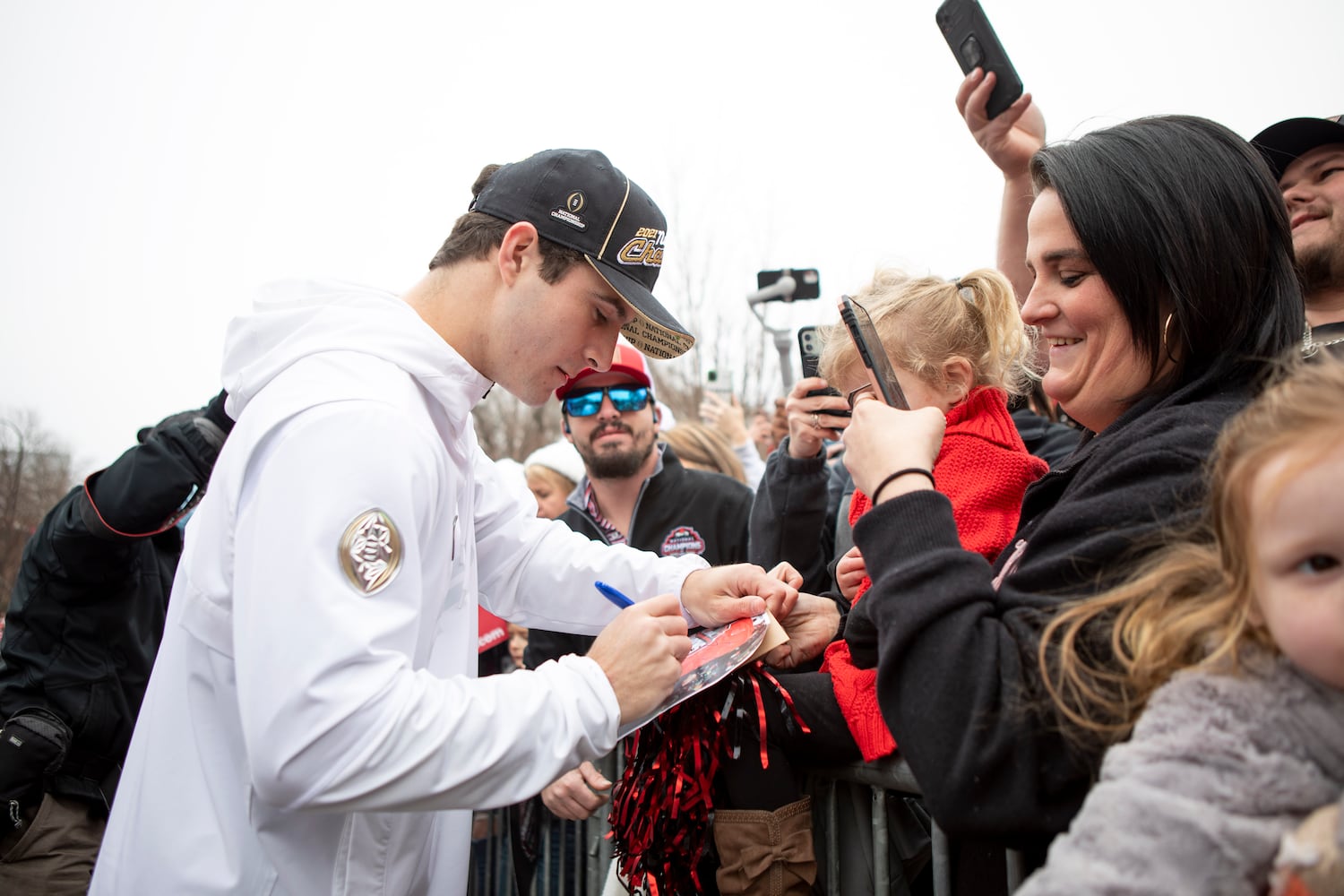 UGA quarterback Stetson Bennett IV signs a poster during the UGA National Championship Celebration Parade in Athens, GA., on Saturday, January 15, 2022. (Photo/ Jenn Finch)