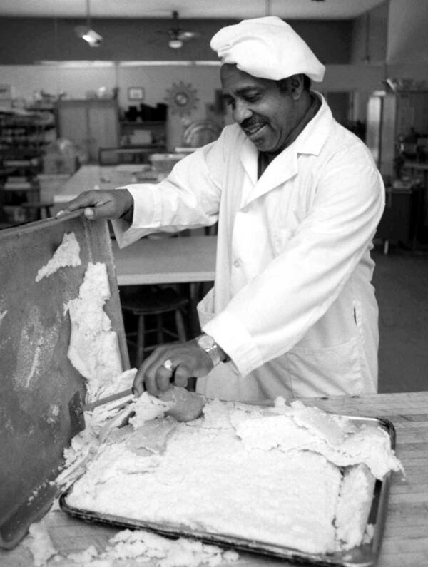  Windsor Jordan, scrapes newly baked cornbread for Thanksgiving turkey dressing in 1971. / AJC file photo