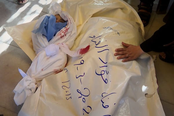 In this image made from an Associated Press video, the bodies of Afnan al-Ghanam, who was 7 months pregnant, and her young son, Mohammed, are prepared for burial in Khan Younis, Gaza Strip, Wednesday, March 19, 2025. They were killed before dawn on Tuesday by an Israeli airstrike. (AP Photo/Mohammad Jahjouh)