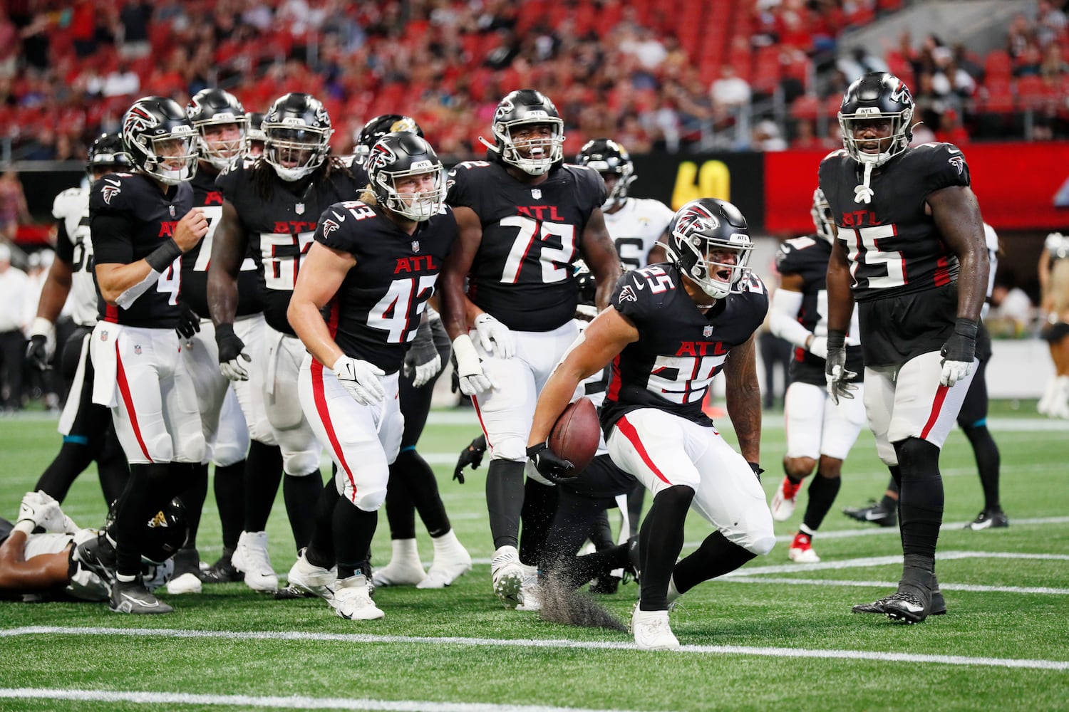 Atlanta Falcons running back Tyler Allgeier (25) celebrates the touchdown surrounded by teammates during the fourth quarter of an NFL preseason game against the Jacksonville, Jaguars on Saturday, August 27, 2022, at the Mercedes-Benz Stadium in Atlanta, Ga.
 Miguel Martinez / miguel.martinezjimenez@ajc.com