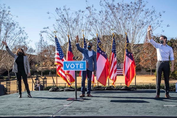 12/21/2020 — Columbus, Georgia — Vice President-elect Kamala Harris (left) waves to the crowd alongside Georgia US Senate Democratic candidates Rev. Raphael Warnock (center) and Jon Ossoff (right) during a car rally in Columbus, Georgia, Monday, December 21, 2020. (Alyssa Pointer / Alyssa.Pointer@ajc.com)