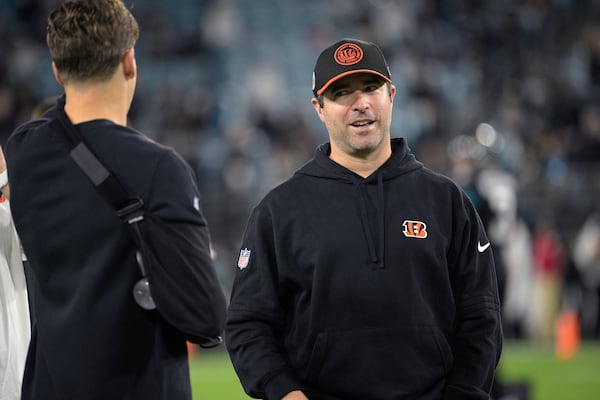 Cincinnati Bengals offensive coordinator Brian Callahan, right, talks with quarterback Joe Burrow on the field before an NFL football game against the Jacksonville Jaguars, Monday, Dec. 4, 2023, in Jacksonville, Fla. (AP Photo/Phelan M. Ebenhack)