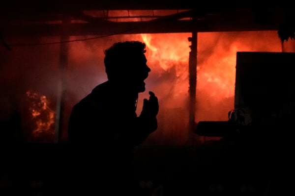 A man screams in front a fire erupting inside a computer shop hit during an Israeli airstrike in central Beirut, Sunday, Nov. 17, 2024.(AP Photo/Bilal Hussein)