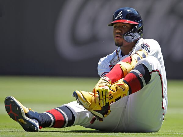 Braves outfielder Ronald Acuna grabs his left foot after falling in the seventh inning against the Toronto Blue Jays Thursday, May 13, 2021, at Truist Park in Atlanta. (Ben Margot/AP)