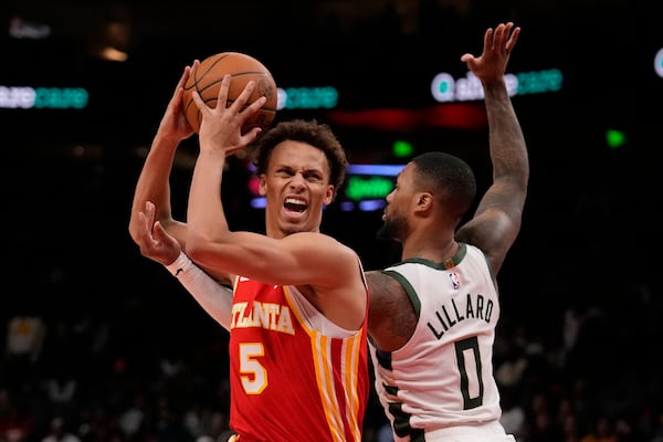 Atlanta Hawks guard Dyson Daniels (5) tries to shoot against Milwaukee Bucks guard Damian Lillard (0) in the first half of an NBA basketball game, Tuesday, March 4, 2025, in Atlanta. (AP Photo/Brynn Anderson)