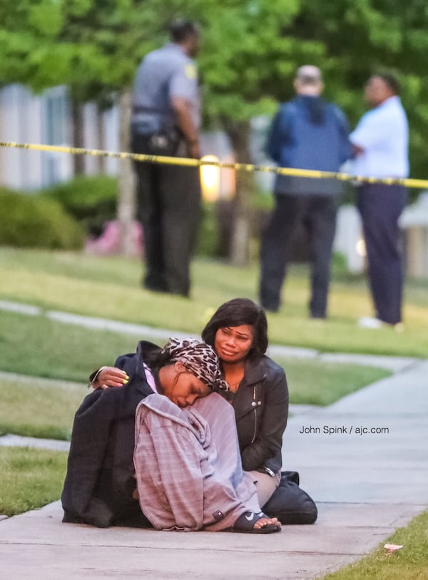 Friends of Demarcus Dragg grieve his death as police continue their investigation outside his home in the 6300 block of Olmadison Place. 