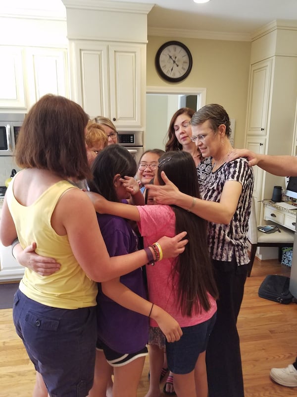 After enjoying the weekend together in Alpharetta, Amy Venn, Lydia Headrick, Julie Neppl, Suzanne Curry and Jackie Wimberly comfort their daughters as they say goodbye to one another. They adopted the girls in China on the same day and have been gathering for reunions since 2007. CONTRIBUTED