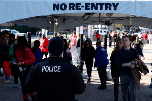 Police watch as fans walk through security checkpoints outside Caesars Superdome ahead of the Sugar Bowl NCAA College Football Playoff game, Thursday, Jan. 2, 2025, in New Orleans. (AP Photo/Butch Dill)