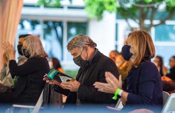 Stephen Schwartz, center, looks over the playbill at the Alliance Theater's temporary Under the Tent theater before the premiere of a new production of his 1978 show "Working." Jenni Girtman for The AJC