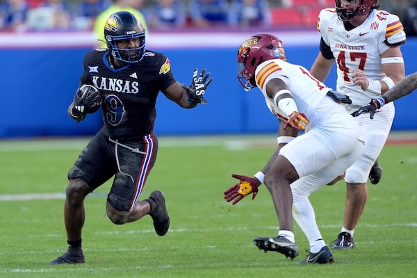 Kansas running back Daniel Hishaw Jr. (9) gets past Iowa State defensive back Ta'Shawn James during the first half of an NCAA college football game Saturday, Nov. 9, 2024, in Kansas City, Mo. (AP Photo/Charlie Riedel)