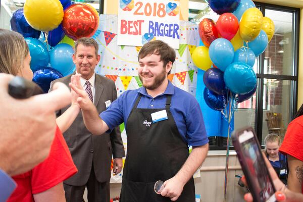 Devin Ferrell, from McDonough, Georgia, celebrates after being named the 2018 Best Bagger for the 22nd annual Kroger Georgia Bag-Off on Wednesday at the Kroger on Glenwood Avenue. Ferrell won $750 in college scholarships and will represent Kroger at the Georgia Food Industry Association's 'Bag Off' in July. (Jenna Eason / Jenna.Eason@coxinc.com)