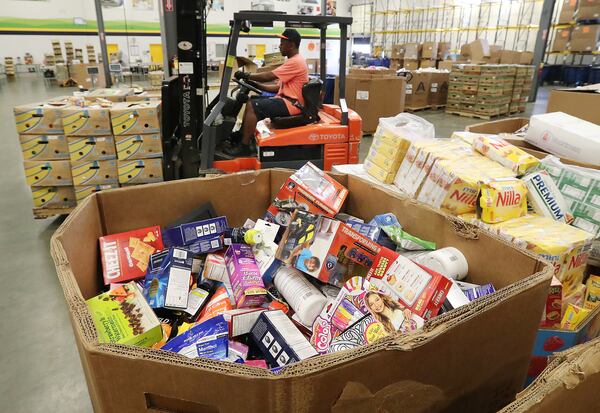 Bruce Beecham moves pallets of donated food items at the Atlanta Community Food Bank. (Curtis Compton /ccompton@ajc.com)