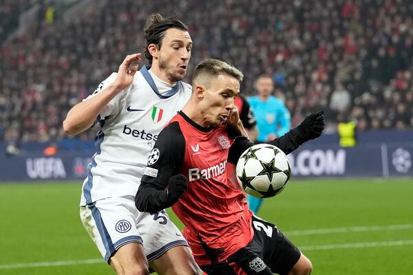 Leverkusen's Alex Grimaldo shields the ball from Inter Milan's Matteo Darmian during the Champions League opening match between Bayer Leverkusen and Inter Milan at the BayArena in Leverkusen, Germany, Tuesday, December 10, 2024. (AP Photo/Martin Meissner)