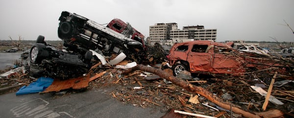 FILE- Cars litter the parking lot at the damaged St. John's Regional Medical Center in Joplin, Mo., Monday, May 23, 2011. (AP Photo/Charlie Riedel, File)