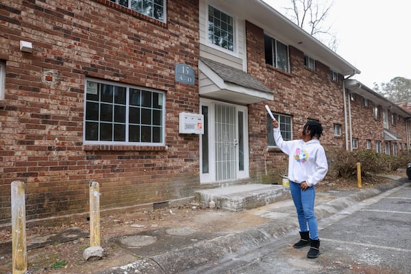 Danielle Russell, a tenant at Pavilion Place Apartments in Atlanta, shows a building near her unit that is under construction following a fire. She says little has changed since the city announced a crackdown on negligent apartment owners in July. (Jason Getz / Jason.Getz@ajc.com)