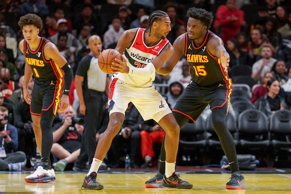 Atlanta Hawks center Clint Capela (15) plays defense on Washington Wizards forward Alexandre Sarr, center, during the first half of an Emirates NBA Cup basketball game, Friday, Nov. 15, 2024, in Atlanta. (AP Photo/Jason Allen)