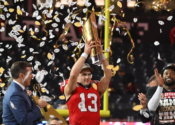 Georgia's quarterback Stetson Bennett (13) holds up the National Championship Trophy during the 2023 College Football Playoff National Championship game at SoFi Stadium, Monday, Jan. 9, 2023, in Inglewood, California. (Hyosub Shin/The Atlanta Journal-Constitution)