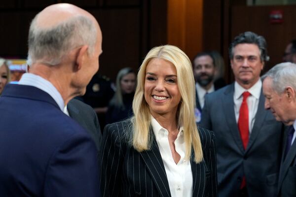 Pam Bondi, President-elect Donald Trump's choice to lead the Justice Department as attorney general, arrives and is greeted by Sen. Rick Scott, R-Fla., left, before she appears before the Senate Judiciary Committee for her confirmation hearing, at the Capitol in Washington, Wednesday, Jan. 15, 2025. (AP Photo/J. Scott Applewhite)