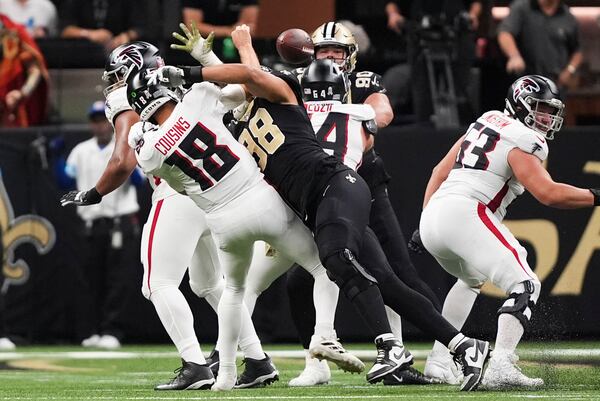 Atlanta Falcons quarterback Kirk Cousins (18) fumbles as he is hit by New Orleans Saints defensive end Payton Turner (98) in the first half of an NFL football game in New Orleans, Sunday, Nov. 10, 2024. The Saints won 20-17. (AP Photo/Gerald Herbert)