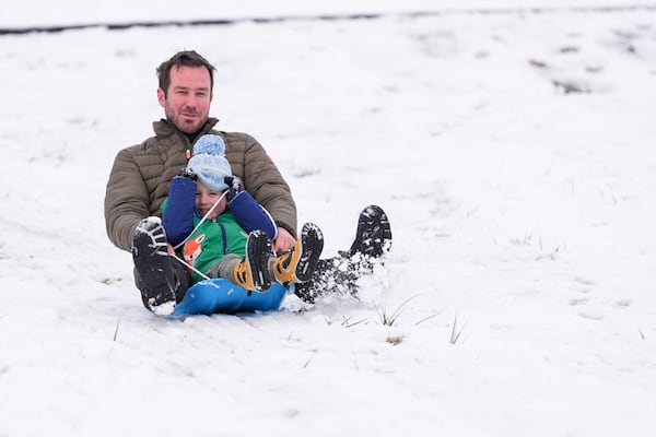 Nate Miller sleds down a hill with his son Henry, Saturday, Jan. 11, 2025, in Nashville, Tenn. (AP Photo/George Walker IV)