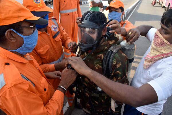 A National Disaster Response Force (NDRF) soldier is fitted with gear before he proceeds to the area from where chemical gas leaked.