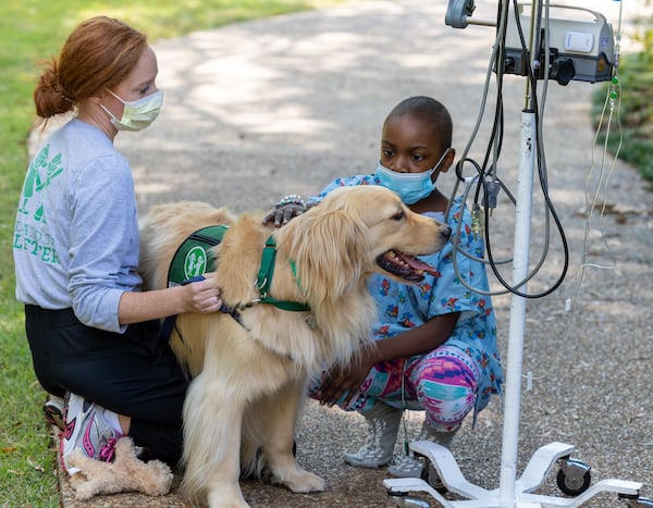 Kara Klein and her therapy dog Reggie visits with patient Skylar Johnson, 7, in the garden at Children's Healthcare of Atlanta Egleston in Decatur.  PHIL SKINNER FOR THE ATLANTA JOURNAL-CONSTITUTION