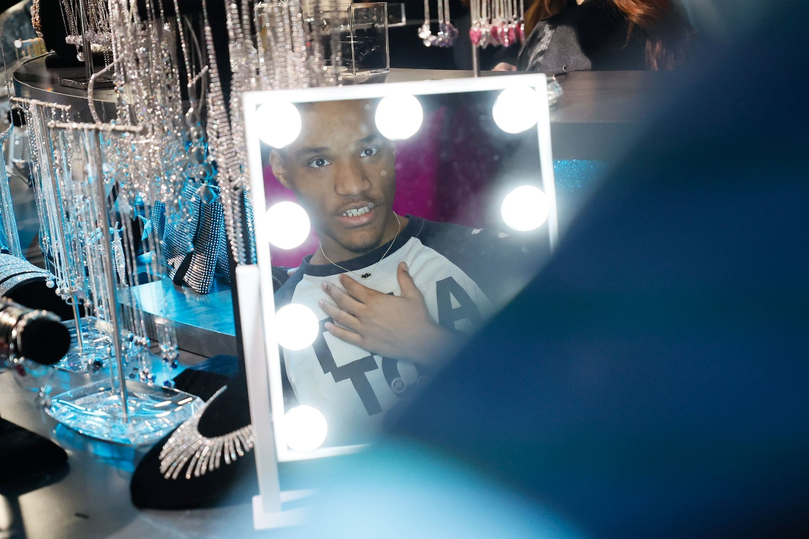 McNair High School junior Benare Hazleton looks at the mirror as he tries on a necklace during “Say Yes to the Prom” at Warner Brothers Discovery's campus in Midtown on Tuesday, Feb. 6, 2024. (Miguel Martinez /miguel.martinezjimenez@ajc.com)