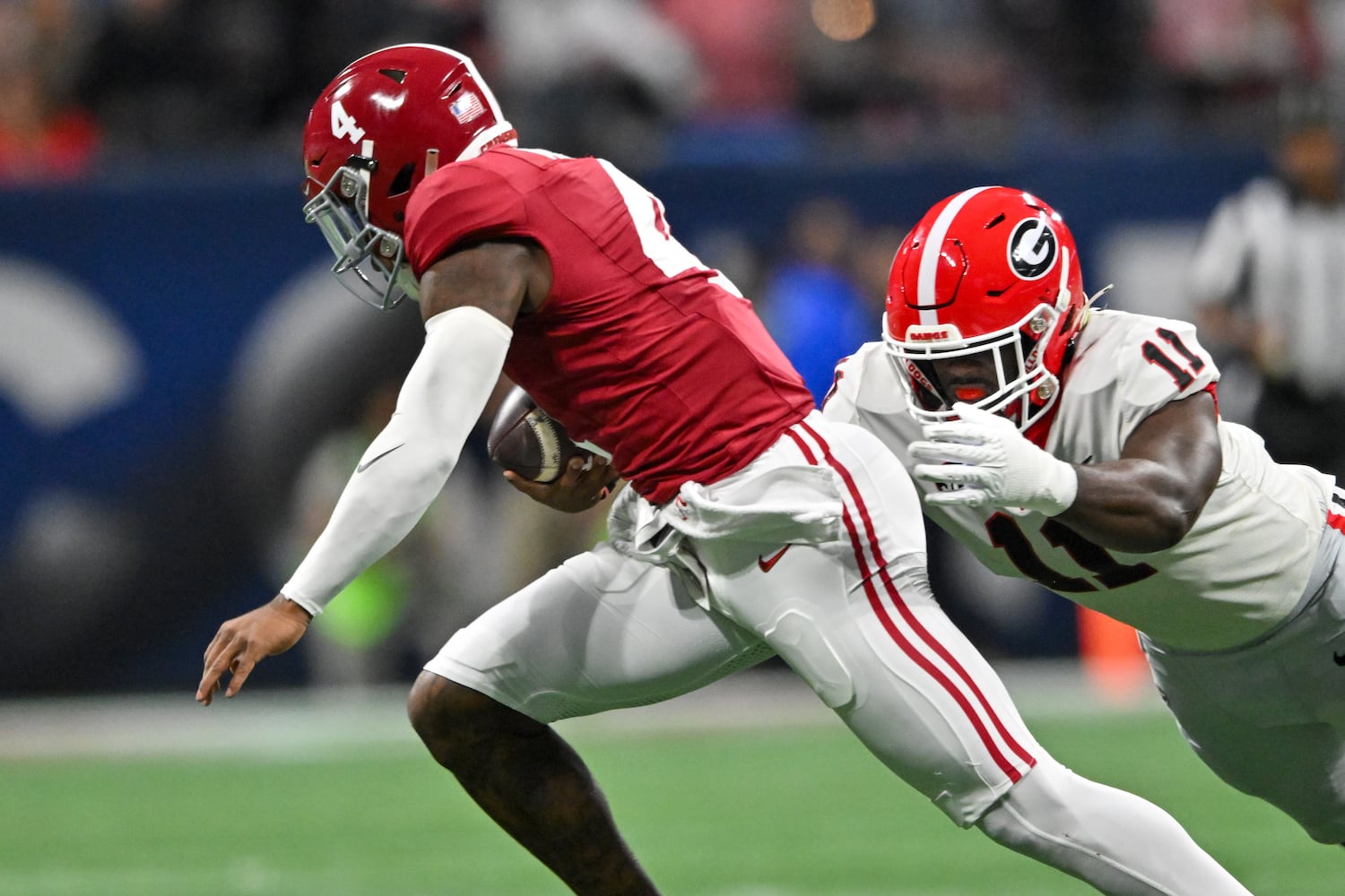 Alabama Crimson Tide quarterback Jalen Milroe (4) is tackled by Georgia Bulldogs linebacker Jalon Walker (11) during the first half of the SEC Championship football game at the Mercedes-Benz Stadium in Atlanta, on Saturday, December 2, 2023. (Hyosub Shin / Hyosub.Shin@ajc.com)