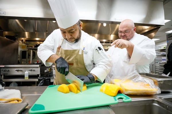 Chef Antonio Nazario, executive chef at Lenbrook retirement community, and Dining General Manager Todd Clements prepare a meal. Nazario and Clements are crafting a special menu for the Thanksgiving Day meal.  
(Miguel Martinez / AJC)