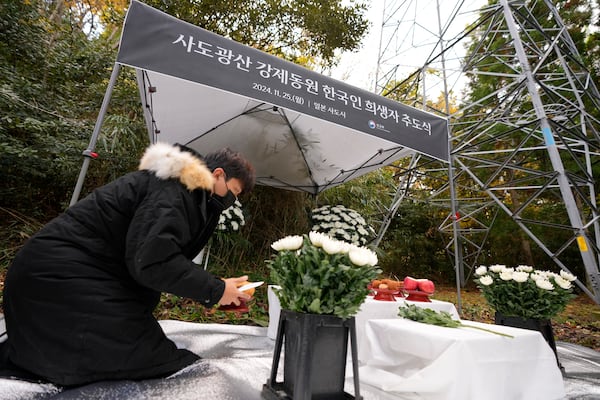 A staff prepare offerings prior to a memorial service held by relatives of Korean victims and South Korean officials in Sado, Niigata prefecture, Japan, Monday, Nov. 25, 2024, after boycotting a memorial organized by Japanese officials. (AP Photo/Eugene Hoshiko)