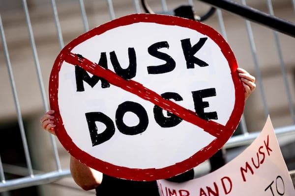 A demonstrator holds a sign during a rally to protest President Donald Trump and Elon Musk policies Feb. 17, 2025, in Los Angeles. (AP Photo/Etienne Laurent, File)