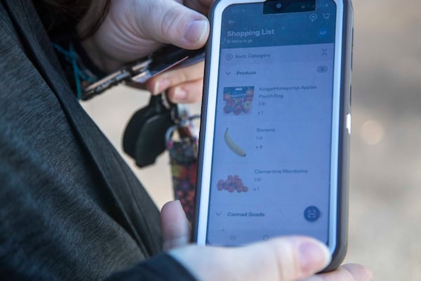 Shipt Shopper April Wright shows a customer's digital shopping list on her phone before heading into a grocery store in Canton. Companies like Shipt are having to hire more workers as online grocery shopping surged during the coronavirus pandemic. (Alyssa Pointer / Alyssa.Pointer@ajc.com)