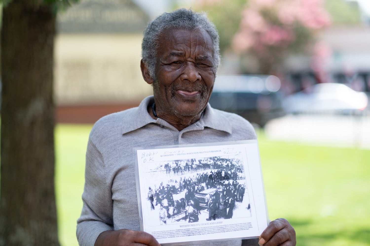 Bobby Kinney shows off a photo from the Atlanta Journal-Constitution that he is in of Dr. Martin Luther King’s funeral procession through Atlanta. Kinney, who said he considered the Kings family, brought the photo to Ebenezer Baptist Church on Sunday, July 16, 2023, for Christine King Farris’ funeral.   (Ben Gray / Ben@BenGray.com)