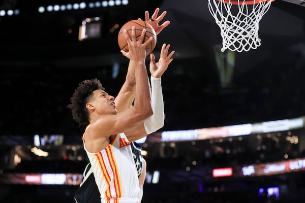 Atlanta Hawks forward Jalen Johnson, front, goes up to shoot against Milwaukee Bucks center Brook Lopez, back, during the first half of a semifinal game in the NBA Cup basketball tournament Saturday, Dec. 14, 2024, in Las Vegas. (AP Photo/Ian Maule)